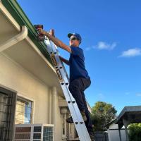 Plumber doing gutter plumbing on Brisbane home roof
