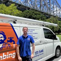 Rhys in fron of Jim's van with Story Bridge in background