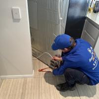 Plumber connectiong fridge to water supply