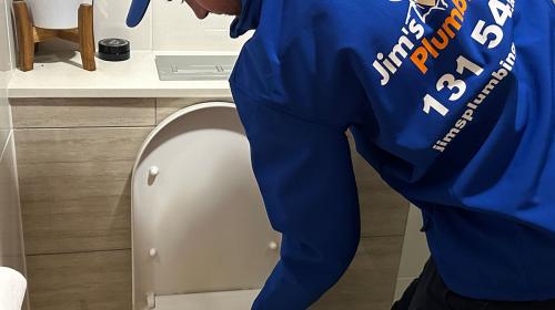 Plumber using a plunger to iunblock a toilet
