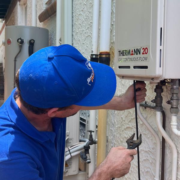 Plumber fixing a tankless hot water system outside