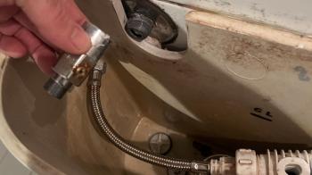 Closeup of plumber fixing valve on toilet cistern
