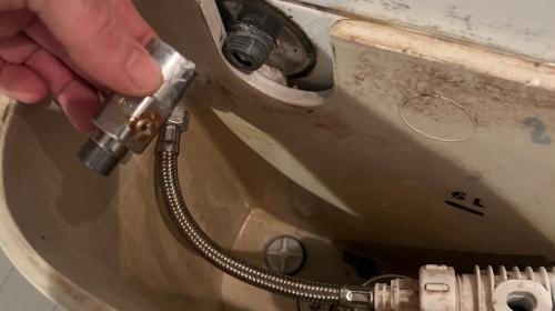 Closeup of plumber fixing valve on toilet cistern